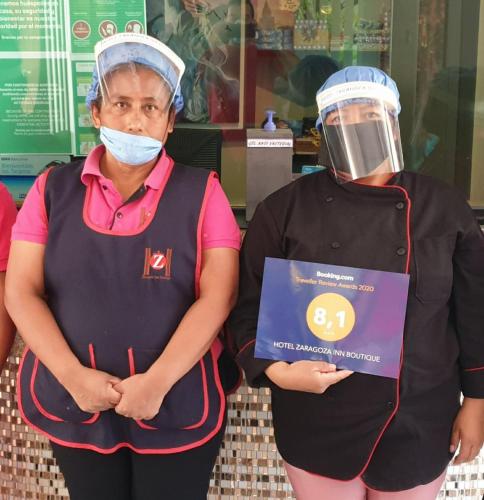 an older woman with a mask on her head standing next to a woman with at HOTEL ZARAGOZA INN BOUTIQUE in Mexico City