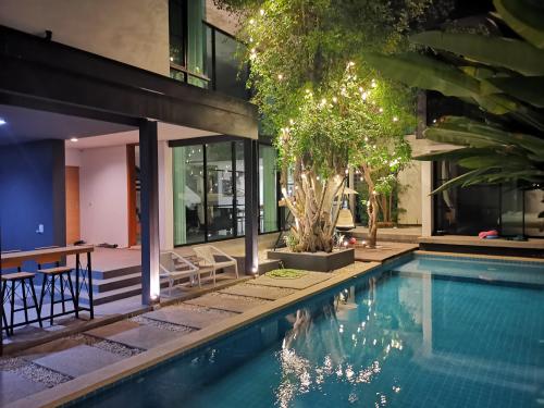 ein Pool vor einem Haus in der Unterkunft V.moon house 清迈奢华私密泳池别墅 in Chiang Mai