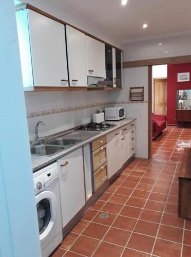 a kitchen with a sink and a washing machine at "A Casa dos Avôs" Suites & Breakfast in Lagos