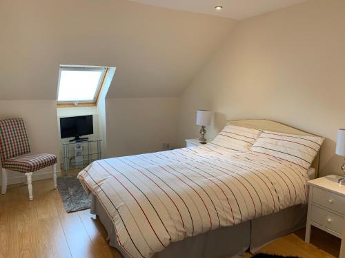 a bedroom with a bed and a chair and a window at Crayford's Guest House in Aberdeen