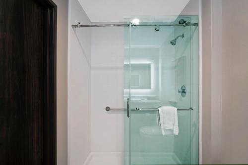 a bathroom with a shower with a glass door at La Quinta by Wyndham Tuscaloosa McFarland in Tuscaloosa
