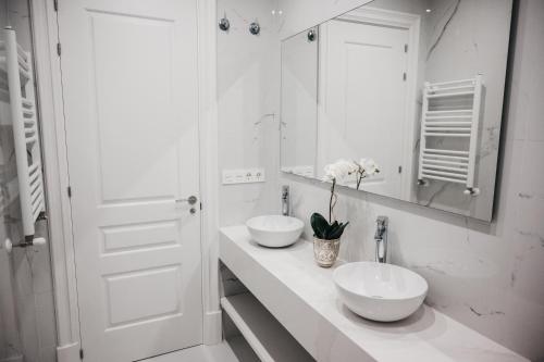 Baño blanco con 2 lavabos y espejo en Apartamento Naiala, en Bilbao