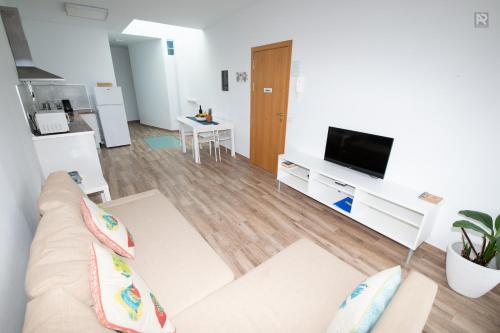 a living room with a couch and a tv at Casa Playa Ondina in Gáldar
