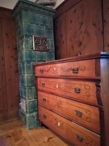 a room with a chest of drawers and a wall at Da Rinota in Alta Val di Non in Malosco
