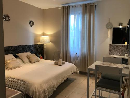 a bedroom with a bed and a desk and a television at Le Marty in Narbonne