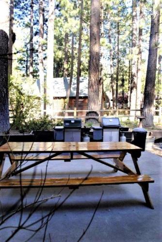 a wooden picnic table sitting in front of trees at Snow Lake Lodge in Big Bear Lake
