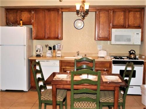 a kitchen with a table and chairs and a white refrigerator at Snow Lake Lodge in Big Bear Lake