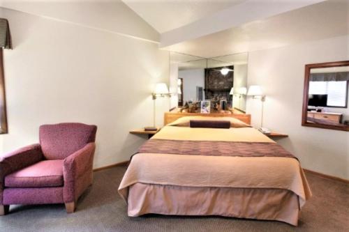 a hotel room with a bed and a chair at Snow Lake Lodge in Big Bear Lake