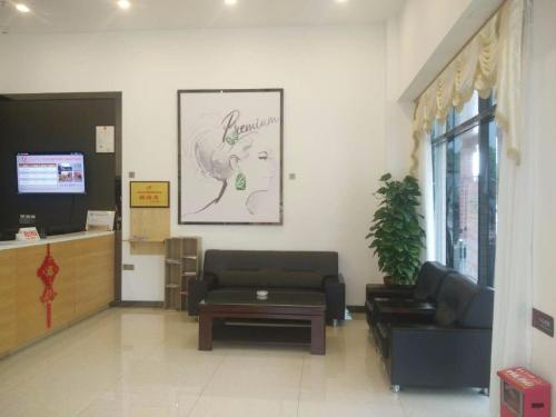 a waiting room with a couch and a table at 7Days Premium Meizhou Fengshun Store in Tangkeng