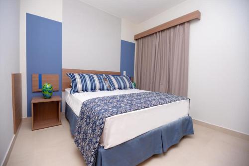 1 dormitorio con 1 cama extragrande y paredes azules en Alta Vista Thermas Resort en Caldas Novas