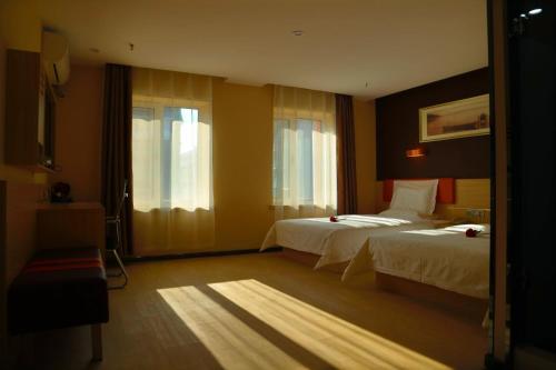 Sipingにある7Days Premium Gongzhuling Railway Station Branchのベッド2台と窓が備わるホテルルームです。