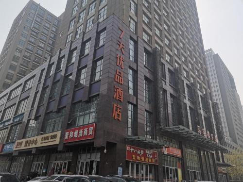 a tall building with a sign on the side of it at 7Days Premium Shijiazhuang East Railway Station Shenghe Square Branch in Shijiazhuang