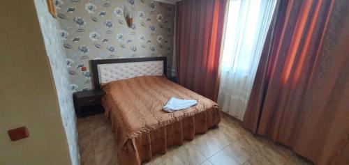 a small bedroom with a bed with a towel on it at LA CANAPELE ROCK in Vama Veche