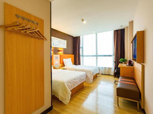 a hotel room with two beds and a window at 7Days Premium Chenzhou Guoqing South Road Branch in Chenzhou