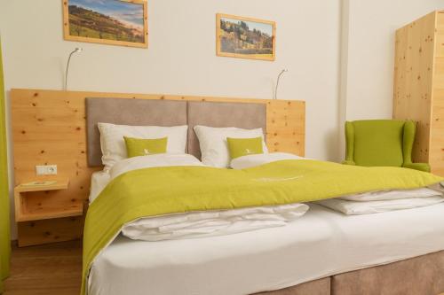 a bedroom with a large bed with a green blanket at Landhotel Moshammer in Waidhofen an der Ybbs
