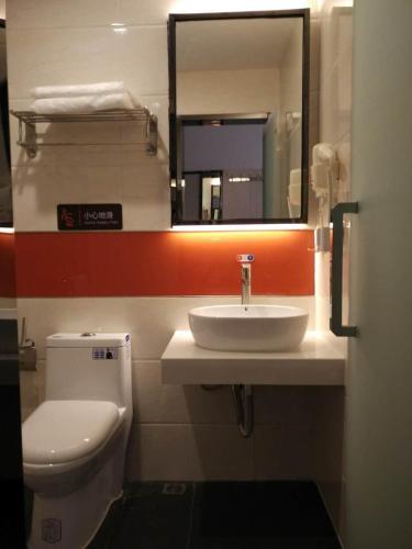 W łazience znajduje się umywalka, toaleta i lustro. w obiekcie 7Days Premium Beijing Fengtai South Road Subway Station Wumei Market Branch w Pekinie