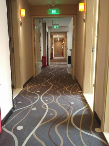 a hallway with a carpet with a swirl pattern on it at 7Days Premium Beijing Fengtai South Road Subway Station Wumei Market Branch in Beijing