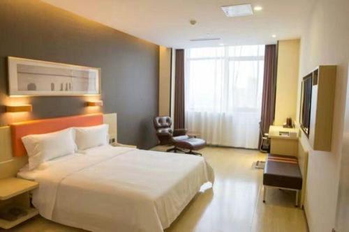 um quarto de hotel com uma cama e uma televisão em 7Days Premium Beijing Fengtai South Road Subway Station Wumei Market Branch em Pequim