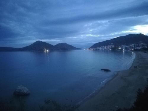 a large body of water with a beach and mountains at Stone House in olive grove in Tolo