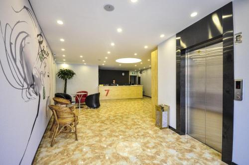 un corridoio con sedie e bancone in un edificio di 7Days Premium Qinghuangdao Hebei Avenue Sidaoqiao Branch a Qinhuangdao