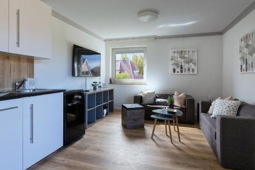 een keuken en een woonkamer met een bank bij Dein Sylt in Westerland