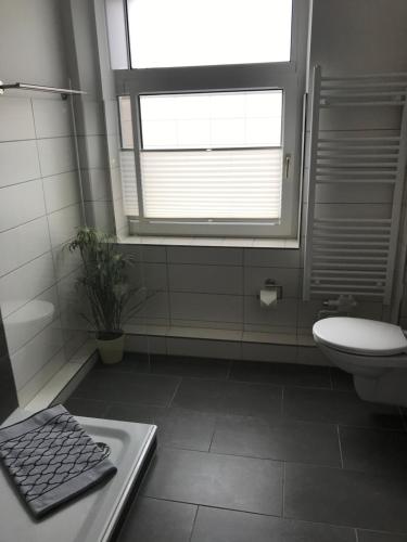 a bathroom with a white toilet and a window at Ferienwohnung am Schlossparkcenter in Schwerin