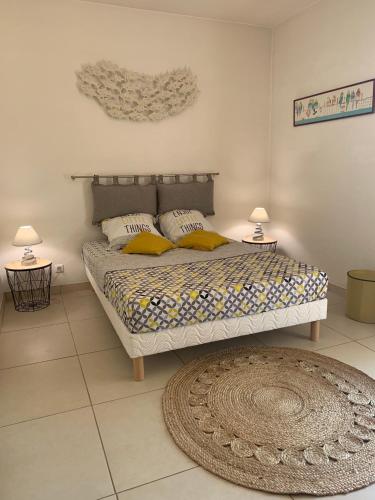 - une chambre avec un lit, deux lampes et un tapis dans l'établissement Le Jacaranda, à Villeneuve-Loubet