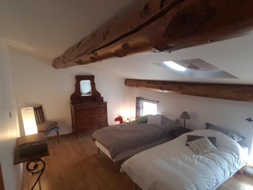 a bedroom with a bed and a dresser in a room at L'Attrape Reve in Saint-Vincent-de-Barrès