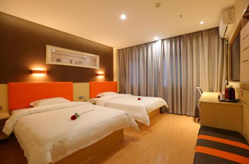 a hotel room with two beds and a window at 7Days Premium Guang'an Chaoyang Avenue Branch in Guang'an
