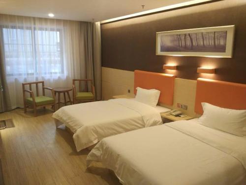 a hotel room with two beds and a table and chairs at 7Days Premium Xi'an Railway Station Central Plaza Airport Bus Branch in Xi'an