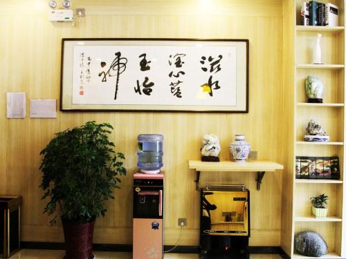 a wall with a picture on the wall with a coffee machine at 7Days Premium Xi'an Lantian Lanxin Road Branch in Xi'an