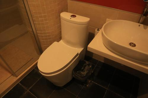 a bathroom with a white toilet and a sink at 7Days Premium Yantai Penglai New Bus Station Branch in Penglai