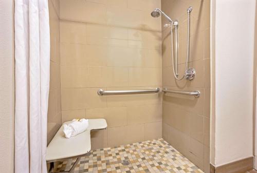a bathroom with a shower with a toilet and a shower curtain at La Quinta Inn & Suites by Wyndham The Woodlands Spring in Spring
