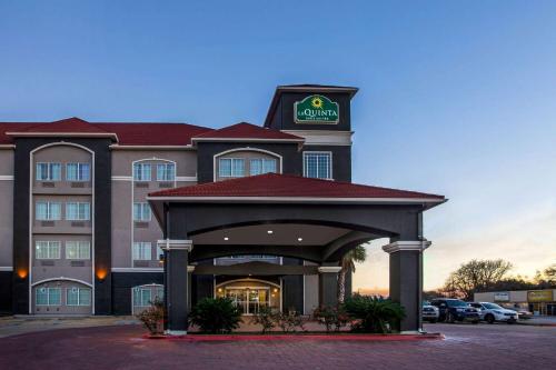 a hotel with a sign on top of a building at La Quinta by Wyndham Columbus TX in Columbus