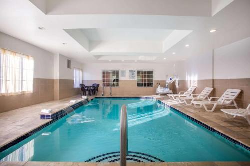 a large swimming pool in a room with chairs at La Quinta by Wyndham Columbus TX in Columbus