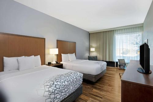 a hotel room with two beds and a flat screen tv at La Quinta by Wyndham Kingman in Kingman