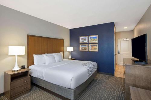 a hotel room with a bed and a flat screen tv at La Quinta by Wyndham Kingman in Kingman