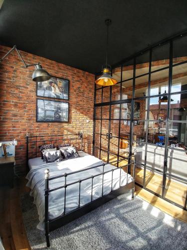 a bedroom with a bed and a brick wall at LOFT 57 CENTRUM in Olsztyn