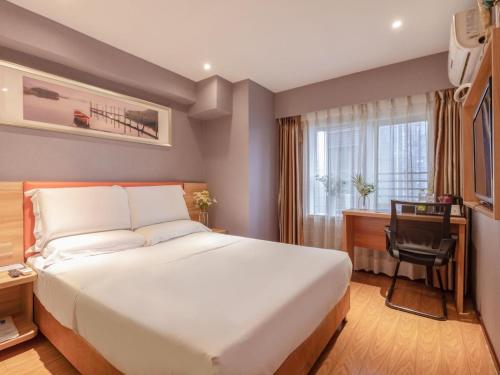 a hotel room with a large bed and a desk at 7Days Premium Chongqing Guanyinqiao Pedestrian Street Light Rail Station Branch in Chongqing