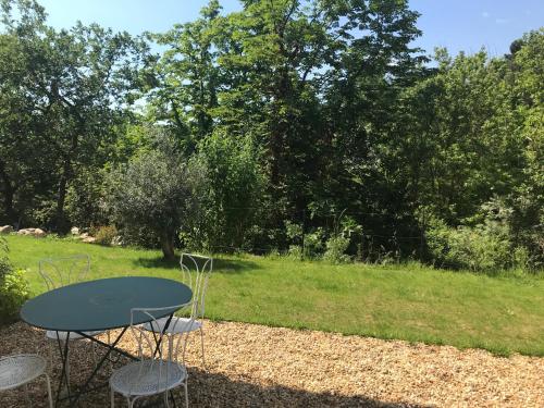 een tafel en twee stoelen in een tuin bij Maison du Prignon in Saint-Marc-Jaumegarde