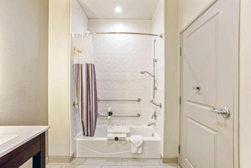 een badkamer met een bad, een wastafel en een douche bij La Quinta by Wyndham Sweetwater East in Sweetwater