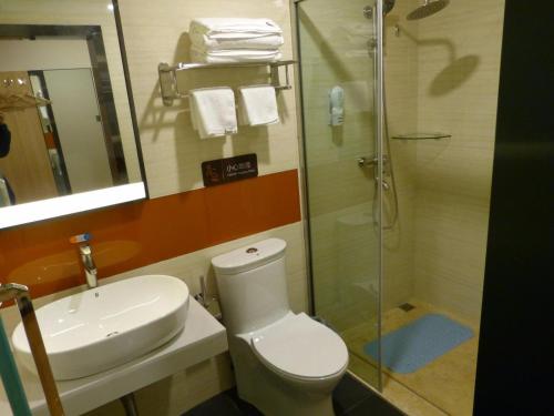 a bathroom with a toilet and a sink and a shower at 7Days Premium Delingha Center Plaza Branch in Delingha