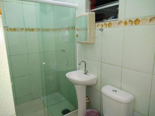 ein Bad mit einer Dusche, einem Waschbecken und einem WC in der Unterkunft Suíte 10 com wifi a 4 min da praia em Caraguá in Caraguatatuba