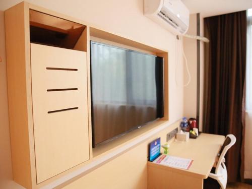 ein Krankenhauszimmer mit einem großen TV an der Wand in der Unterkunft 7Days Premium Beijing Dongba Branch in Peking