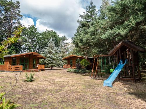 a playground with a slide in front of a cabin at Zielony zakątek Tomasz Laskowski in Ładzin