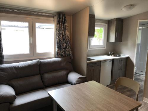 a living room with a couch and a table at Bungalows y Mobil Homes Camping Regio in Santa Marta de Tormes