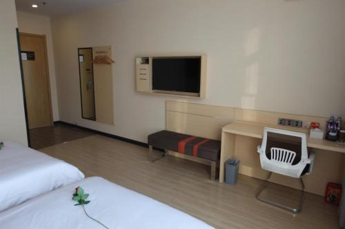 a hotel room with two beds and a television at 7Days Premium Harbin Xuefu Road Branch in Harbin
