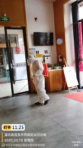 a person dressed in protective gear standing outside a store at 7Days Premium Yichang Wanda Plaza Canal Park Branch in Yichang