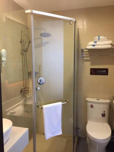 a bathroom with a shower with a toilet and a sink at 7Days Premium Yichang Wanda Plaza Canal Park Branch in Yichang