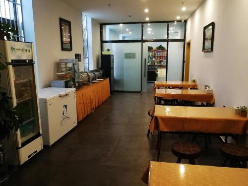 a restaurant with tables and chairs in a room at 7Days Premium Shijiazhuang Jianhua South Avenue South Second Ring Branch in Shijiazhuang